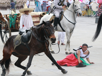 A female rider dressed as a Mexican Revolutionary woman and her horse have an accident during the parade marking the 114th anniversary of th...