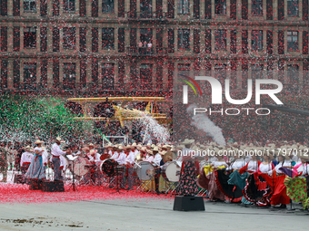 Confetti in the colors of the Mexican flag (green, white, and red) is thrown at the end of the parade on the occasion of the 114th anniversa...