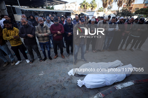 People pray next to the bodies of Palestinians killed in an Israeli strike at Al-Aqsa Martyrs Hospital in Deir Al-Balah, in the central Gaza...