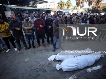 People pray next to the bodies of Palestinians killed in an Israeli strike at Al-Aqsa Martyrs Hospital in Deir Al-Balah, in the central Gaza...