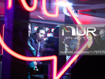 Fernando Alonso speaks to the press as seen through a neon sign ahead of the Formula 1 Heineken Silver Las Vegas Grand Prix in Las Vegas, Ne...