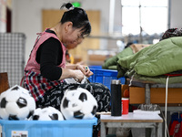 Workers make footballs by hand for export to overseas markets such as Japan at a sports goods factory in Suqian, Jiangsu province, China, on...