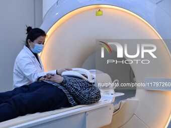 A medical worker performs an MRI exam on a patient in Handan, Hebei province, China, on January 1, 2022. (