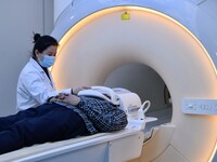 A medical worker performs an MRI exam on a patient in Handan, Hebei province, China, on January 1, 2022. (