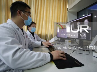 A medical worker examines an MRI image in Handan, Hebei province, China, on January 1, 2022. (