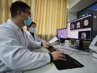 A medical worker examines an MRI image in Handan, Hebei province, China, on January 1, 2022. (