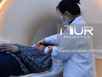 A medical worker performs an MRI exam on a patient in Handan, Hebei province, China, on January 1, 2022. (