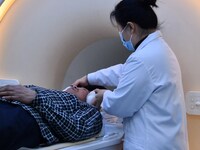 A medical worker performs an MRI exam on a patient in Handan, Hebei province, China, on January 1, 2022. (