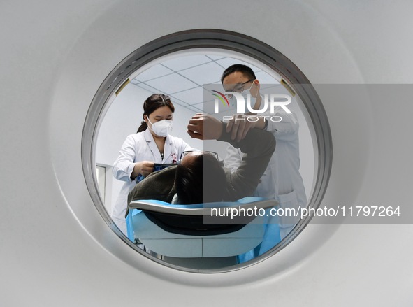 A medical worker performs a CT examination on a patient in Handan, Hebei province, China, on January 1, 2022. 