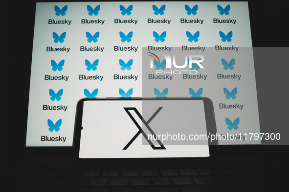 The X (formerly Twitter) logo appears on a smartphone screen, and Bluesky logos appear in the background on a computer screen in this photo...