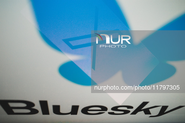 The X (former Twitter) logo appears on a smartphone screen, and a Bluesky logo appears on a computer screen in this photo illustration in At...