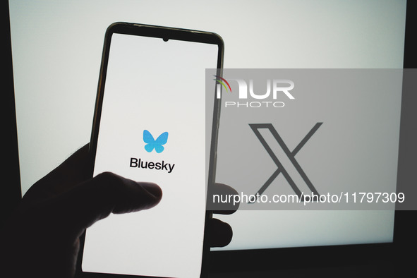 The Bluesky logo appears on a smartphone screen, and an X (former Twitter) logo appears on a computer screen in this photo illustration in A...