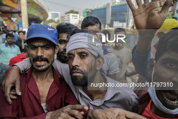 An injured automatic three-wheel driver leans on his fellow driver after a clash with the Bangladesh Armed Forces in Dhaka, Bangladesh, on N...