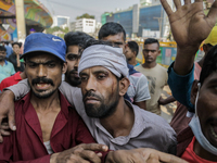 An injured automatic three-wheel driver leans on his fellow driver after a clash with the Bangladesh Armed Forces in Dhaka, Bangladesh, on N...