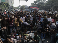 Automatic three-wheel drivers shout slogans as they block the roads and railway track after the high court orders the termination of three-w...