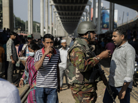 Commuters walk past a blocked rail track during a protest by Automatic Three Wheel Drivers in Dhaka, Bangladesh, on November 21, 2024. (