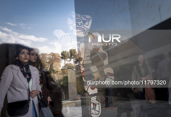 Iranian women walk past ''Cherche Aubaine'' from the series ''Deputation'' by Jean Dubuffet, the French painter and sculptor, while visiting...