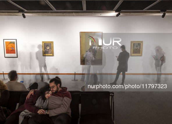 A young Iranian couple rests while people explore the ''Eye to Eye: Portraiture in Modern and Contemporary Art'' exhibition at the Museum of...