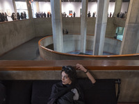 A young Iranian woman rests while people explore the ''Eye to Eye, Portraiture in Modern and Contemporary Art'' exhibition at the Museum of...