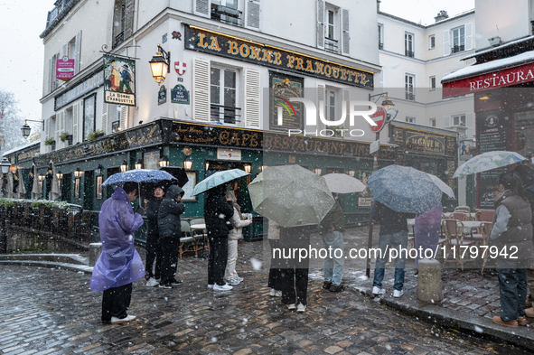 A tourist group stands in Montmartre during heavy snowfall as Paris is placed under the second highest weather warning by the French nationa...