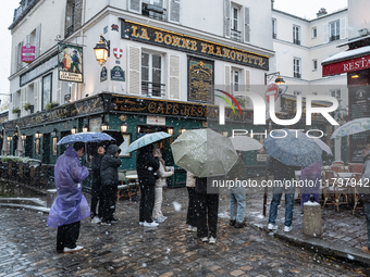 A tourist group stands in Montmartre during heavy snowfall as Paris is placed under the second highest weather warning by the French nationa...