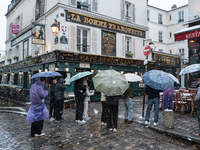 A tourist group stands in Montmartre during heavy snowfall as Paris is placed under the second highest weather warning by the French nationa...