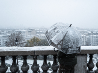 A tourist watches the heavy snowfall as Paris is placed under the second highest weather warning by the French national weather service for...