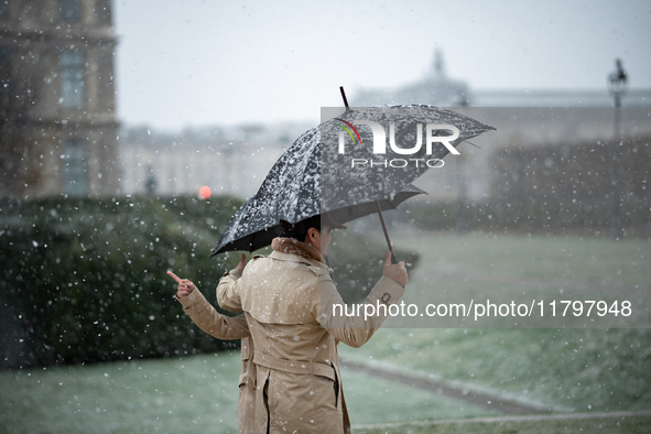 A couple stands in heavy snowfall as Paris is placed under the second highest weather warning by the French national weather service for sno...