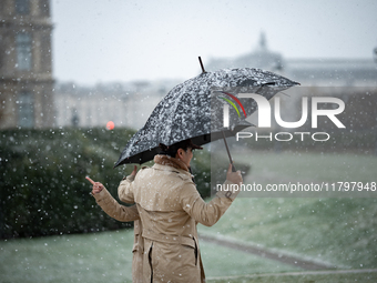 A couple stands in heavy snowfall as Paris is placed under the second highest weather warning by the French national weather service for sno...