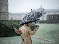 A couple stands in heavy snowfall as Paris is placed under the second highest weather warning by the French national weather service for sno...