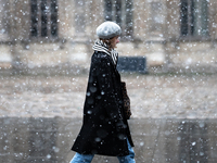 A woman walks in the courtyard of the Louvre Museum in heavy snowfall as Paris is under the second highest weather warning by the French nat...