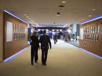 In Belgium, in the corridor to Parliament offices, on November 20, 2024, delegates and visitors walk through a sleek, modern hallway lined w...