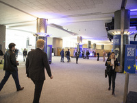 In Belgium, in the corridor to Parliament offices, on November 20, 2024, delegates and visitors walk through a sleek, modern hallway lined w...