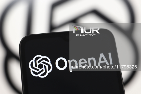 The OpenAI logo appears on a smartphone screen and in the background on a computer screen in Reno, United States, on November 21, 2024. 