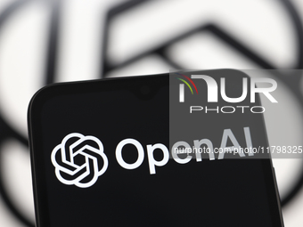 The OpenAI logo appears on a smartphone screen and in the background on a computer screen in Reno, United States, on November 21, 2024. (