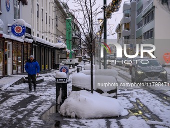 A person walks down a street in Akureyri, Iceland, on November 19, 2024. (