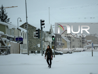 A person walks down a street in Akureyri, Iceland, on November 19, 2024. (