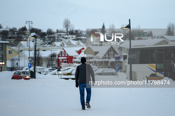 A person walks down a street in Akureyri, Iceland, on November 19, 2024. 