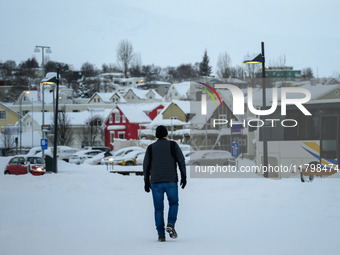 A person walks down a street in Akureyri, Iceland, on November 19, 2024. (