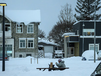 A person sits on a bench on one of the streets in Akureyri, Iceland, on November 20, 2024. (