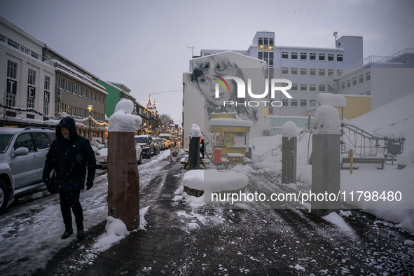 A person walks down a street in Akureyri, Iceland, on November 19, 2024. 