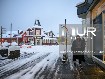 A person walks down a street in Akureyri, Iceland, on November 19, 2024. (