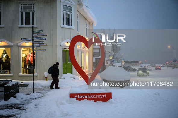 A person walks down a street in Akureyri, Iceland, on November 19, 2024. 