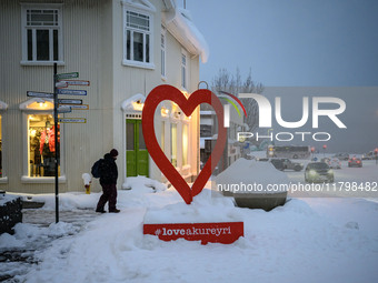 A person walks down a street in Akureyri, Iceland, on November 19, 2024. (