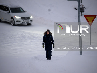 A person walks down a street in Akureyri, Iceland, on November 19, 2024. (