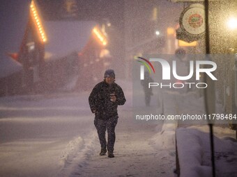 A person walks down a street in Akureyri, Iceland, on November 19, 2024. (