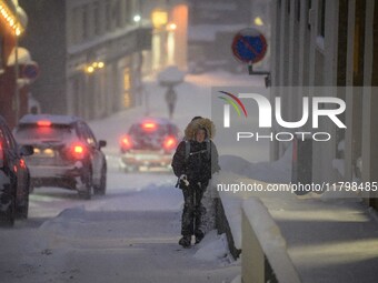 A person walks down a street in Akureyri, Iceland, on November 19, 2024. (