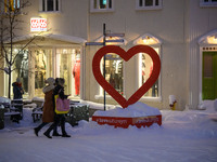 Several people walk down a street in the town of Akureyri, Iceland, on November 19, 2024. (