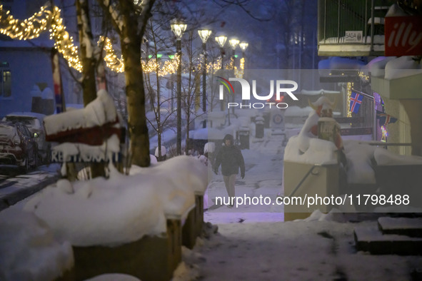 A person walks down a street in Akureyri, Iceland, on November 19, 2024. 