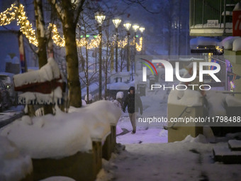 A person walks down a street in Akureyri, Iceland, on November 19, 2024. (